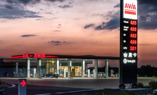 Obraz stacji paliw z dystrybutorami oferującymi benzynę, olej napędowy i gaz LPG od AVIA. Wyświetlane ceny dla oleju napędowego, benzyny i LPG. Tankuj24, SD Eibar.