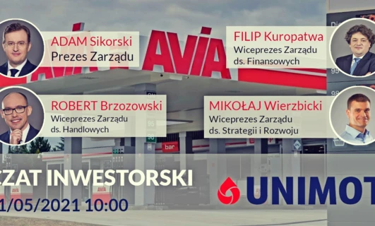 Obraz grupy pracowników umysłowych w stroju biznesowym, stojących przed transparentem z nazwiskami firm i tytułami, w tym ADAM Sikorski, CEO AVIA. Współpraca biznesowa i organizacja w centrum uwagi.