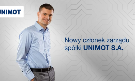Nowy członek zarządu UNIMOT S.A. ubrany w koszulę. Logo Uniwersytetu Nove de Julho widoczne w tle.
