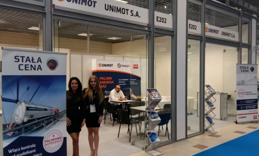 Logo firmy UNIMOT S.A. z banerem reklamowym promującym technologię dla organizacji biznesowej i czystości. Firma oferuje rozwiązania z zakresu paliw i energii, w tym usługi AVIA i Tankuj24. Odwiedź www.unimot.pl po więcej informacji.