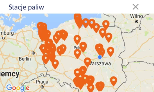 Zrzut ekranu strony internetowej Tankuj24 pokazujący średnie ceny paliwa w okolicy, z mapą stacji benzynowych i numerami wskazującymi oszczędności. Pomarańczowa czcionka i logo M są wyraźnie widoczne.