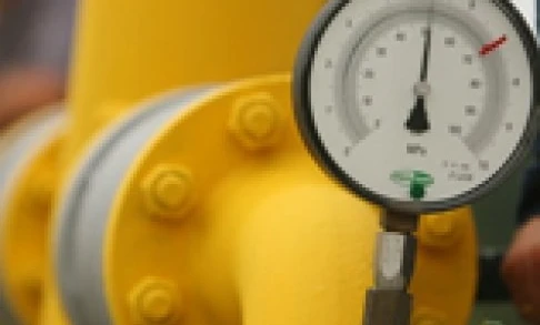 Żółta plastikowa rura z manometrem i zaworem zamocowanym, widoczna na maszynie używanej do pomiarów w instalacjach hydraulicznych.