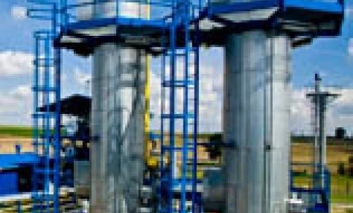 Metalowa stalowa cylinder widziana wewnątrz fabryki, prezentująca inżynierię i produkcję przemysłową. Wykonana z materiałów kompozytowych przechowywanych w metalowym zbiorniku.