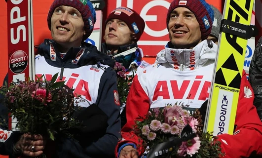 Osoba uśmiecha się podczas uprawiania sportów zimowych na zewnątrz, w śniegu. Przygoda i zabawa czekają w indywidualnym sporcie. #SportyZimowe #RekreacjaNaŚwieżymPowietrzu