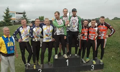 Zespół dumnie stoi na podium w dopasowanych strojach sportowych, świętując swoje mistrzowskie zwycięstwo na zawodach. #Społeczność #Zespół #StrojeSportowe #Mistrzostwo