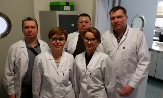 Uśmiechnięty profesjonalista medyczny w białym płaszczu stoi w laboratorium instytutu badawczego, gotowy do udzielenia opieki medycznej. Badacz AGA z grupy Aga Rangemaster.